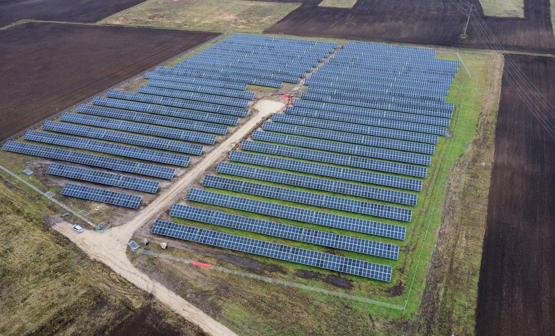Saulės elektrinės parkas iš paukščio skrydžio tarp dirbamų laukų
